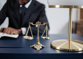 Elegant legal office with a close-up of golden scales of justice on a sleek dark desk.
