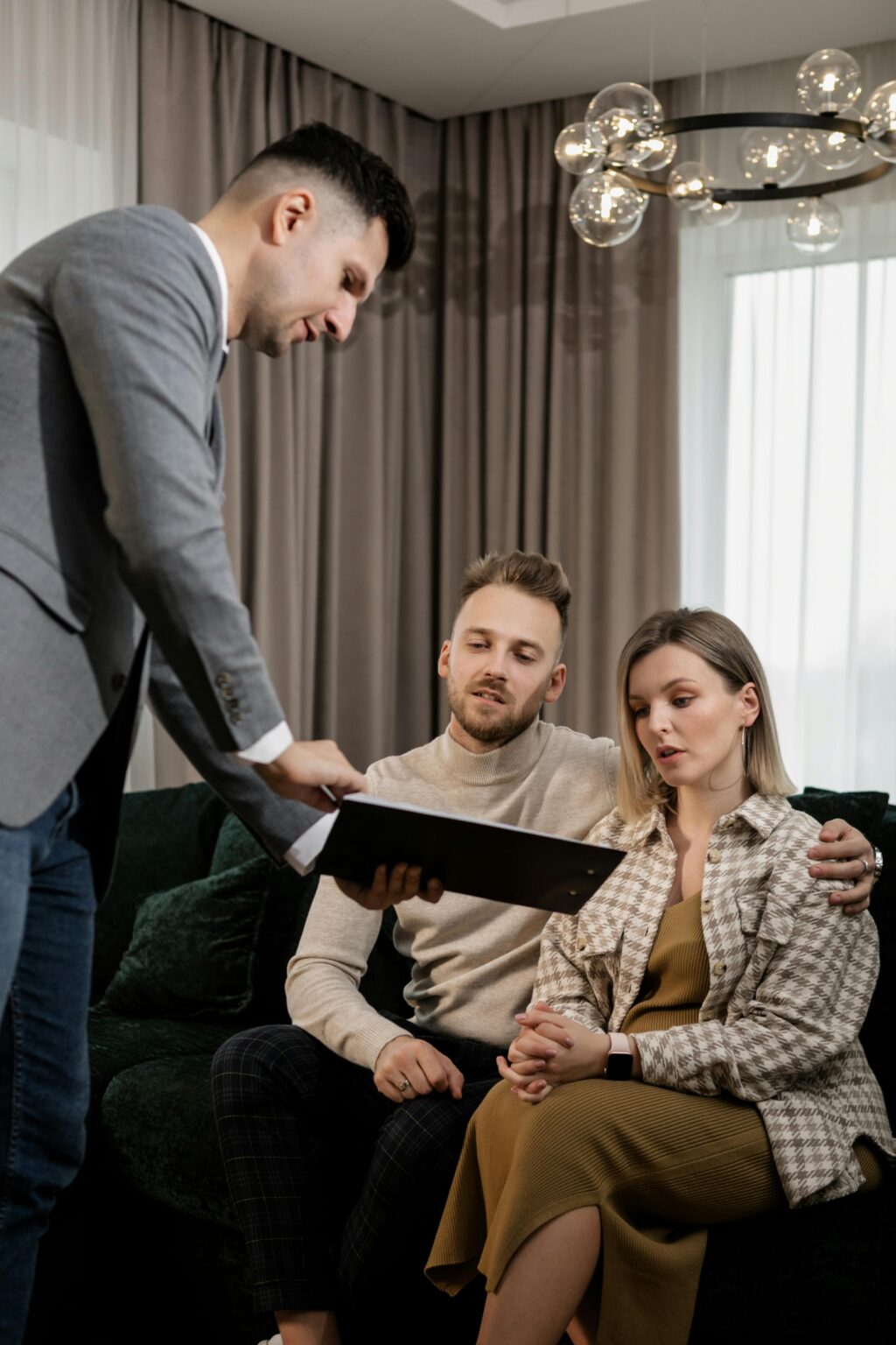 Real estate agent presenting a housing proposal to a couple indoors.
